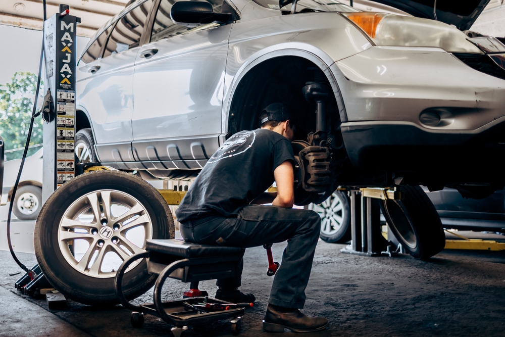 Steering and Suspension Repair in Westfield, MA At LaFlamme's Auto & Truck Services. Mechanic inspecting a vehicle's suspension system during service