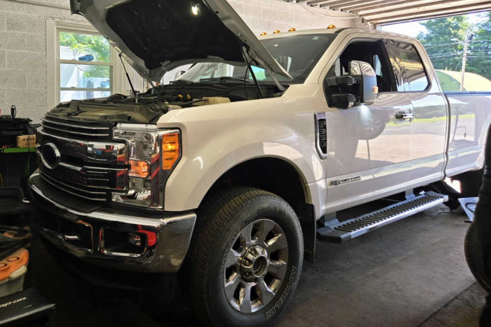 State Inspection in Westfield, MA At LaFlamme's Auto & Truck Services. Image of hite Ford pickup truck undergoing state inspection in a service bay
